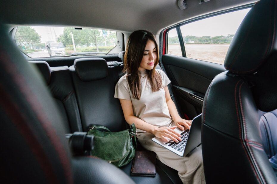 Woman using a laptop in a car