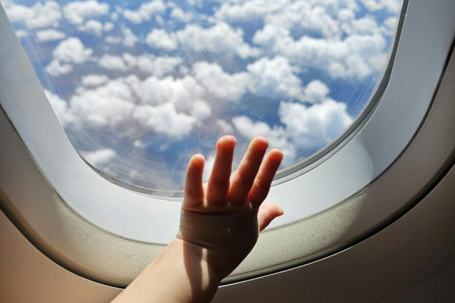 Child's hand on airplane window